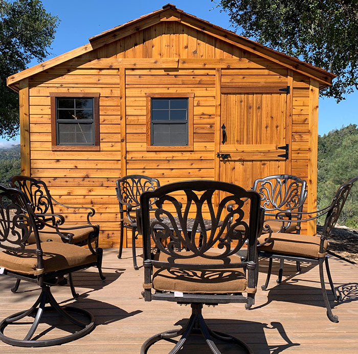 Outdoor Living Today Sunshed Garden Shed 12x12 on a wooden deck with chairs and a coffee table