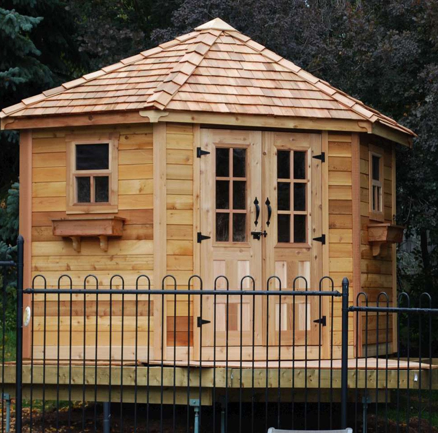 The Penthouse outdoor corner shed placed on a raised deck. 